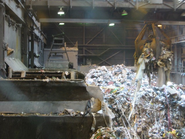 Image of crane scooing up garbage