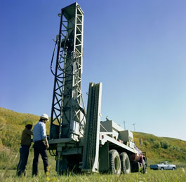 Operators preparing a hole for the explosive charges used in seismic exploration