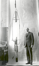image of Dr. Robert Goddard with his double acting engine rocket in 1925